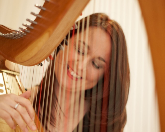 A bride gets photographed with the harp